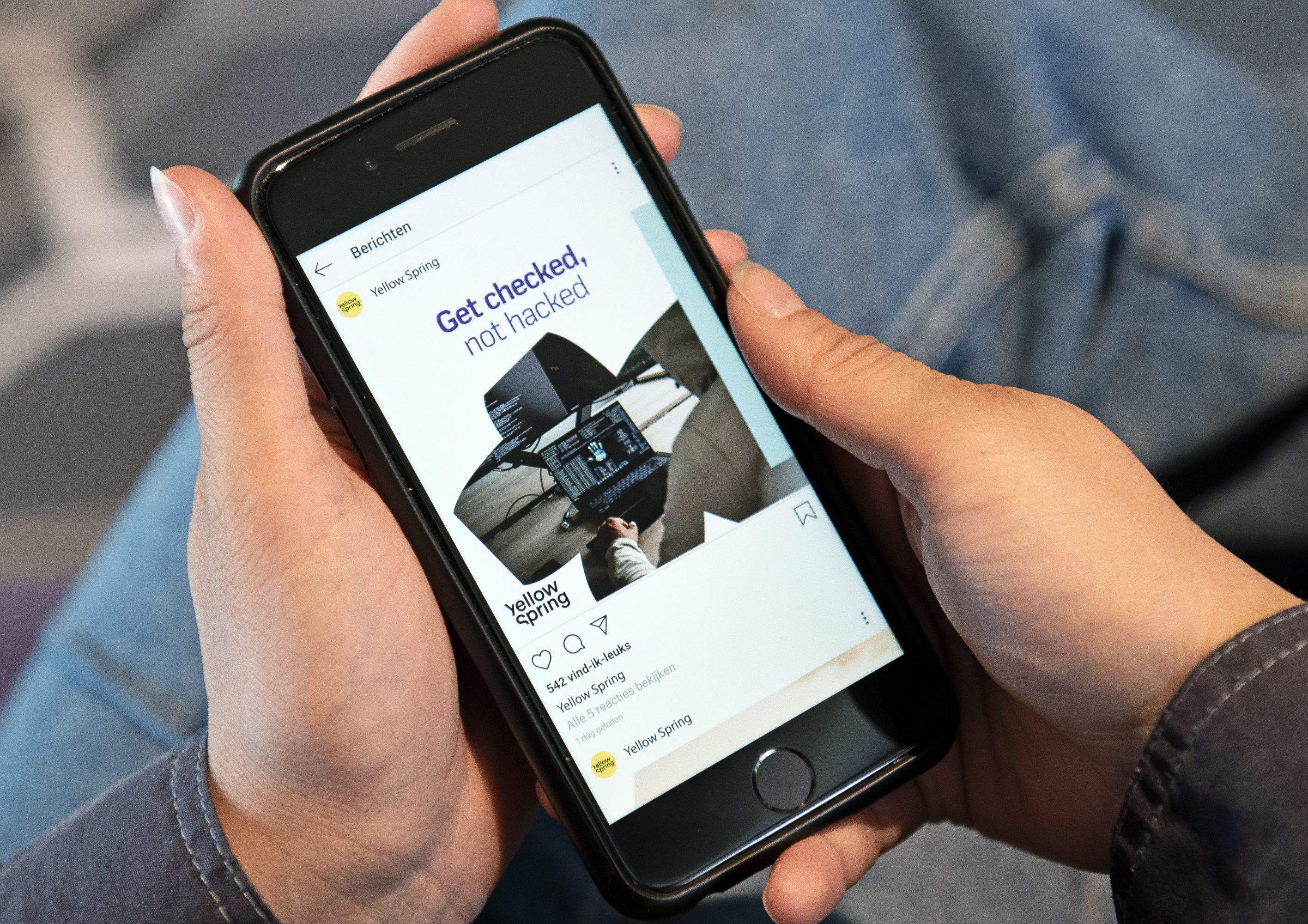 Telefoon in handen met op beeldscherm social media open.